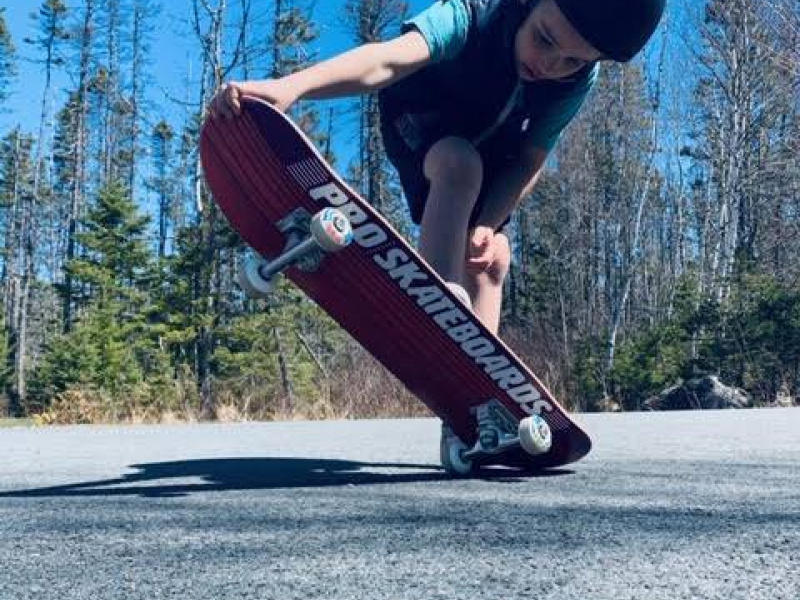 Young child skateboarding in Hubbards community.