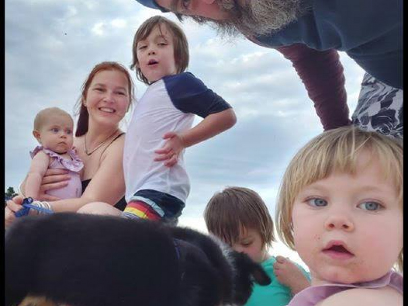 Upward camera angle of the Herlihy family at the beach.