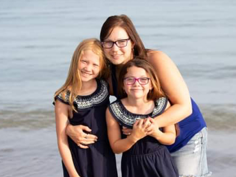 Maggie McCulley and her two daughters posing on the beach