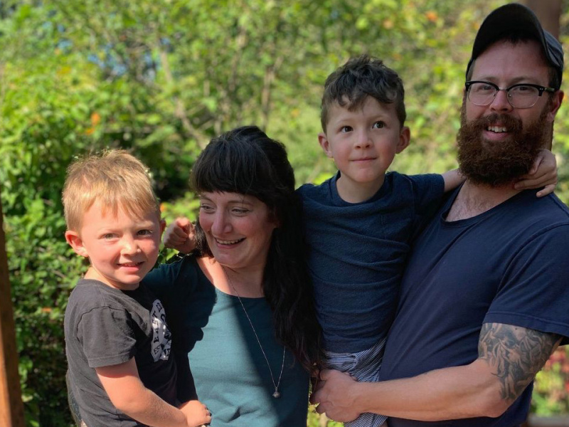 Portrait of the Mennier family including Mom, Dad, and two young boys. 