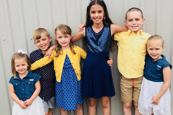 Carol Simms grandchildren, ranging in age, smiling for the camera.