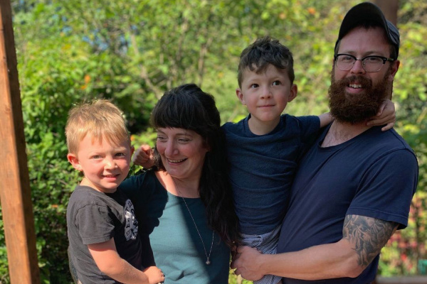 Portrait of the Mennier family including Mom, Dad, and two young boys.